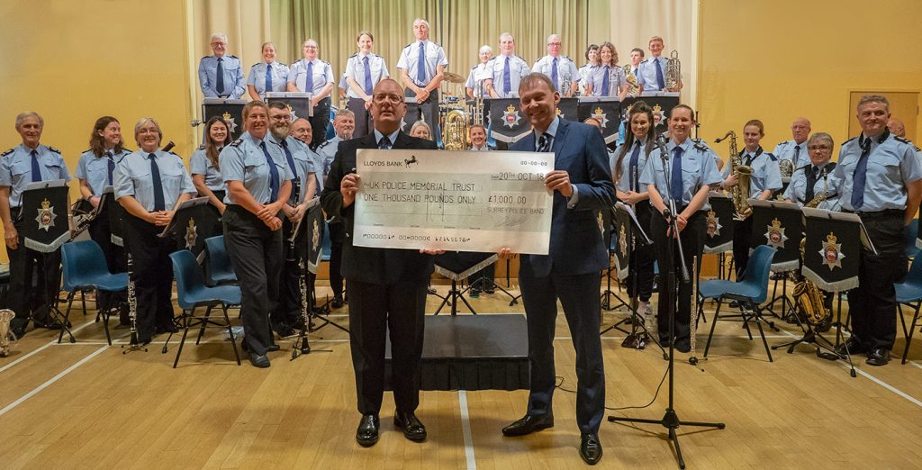 Chris Webb from the UK Police Memorial receiving a cheque from Surrey Police Band Musical Director Graham Atterbury.